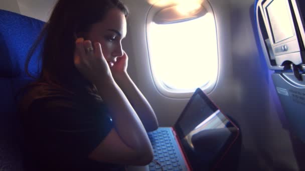 Uma mulher a voar num avião. Feminino turista laptop de trabalho em viagens aéreas — Vídeo de Stock