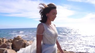 Taş kumsalda yürüyen lüks kadın. Deniz kıyısında moda kadın