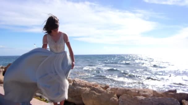 Mulher elegante a saltar na costa rochosa. Menina sensual desfrutar paisagem do mar — Vídeo de Stock