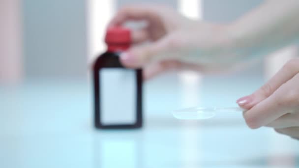 女性の手が薬瓶からシロップを注ぐします。インフルエンザの予防。健康管理 — ストック動画