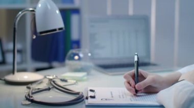 Kadın doktor el tıbbi işyerinde belge yazma. Klinik sağlık