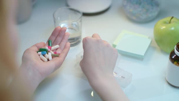 Arzt nimmt Tabletten in Tablettenspender. Frau sortiert Drogen in Veranstalter — Stockvideo