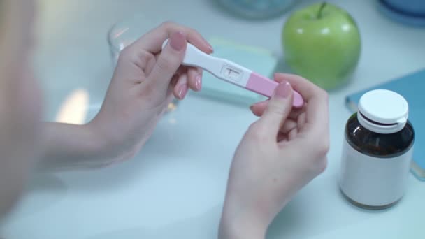 Positivt graviditetstest i kvinnliga händer. Test pregnacy med en rad — Stockvideo