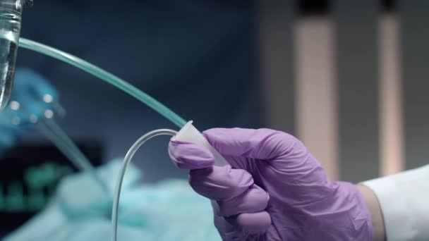 Anästhesist Hand steuert Drop Counter Flasche. Tropfen auf den heißen Stein — Stockvideo