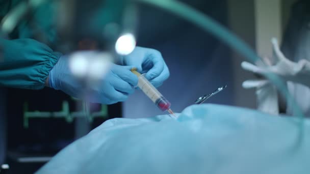 Sebész kezében tartja a fecskendő vörös folyadék. Orvosi működését — Stock videók