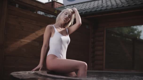 Mujer modelo en el baño caliente. Modelo de trajes de baño al aire libre. Chica caliente en traje de baño blanco — Vídeos de Stock