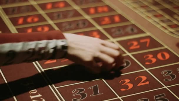 Krupier biorąc do ręki i rzucanie czerwona kostka na hazard tabeli — Wideo stockowe