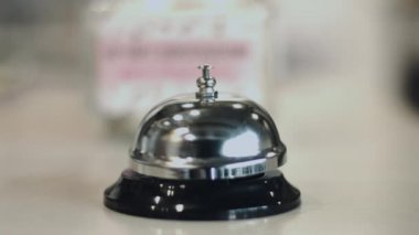 İnsan eli gümüş servis zil otel resepsiyon masası üzerinde