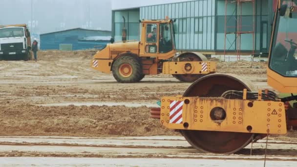 Yol inşaat sitesinde çalışan sarı yol silindiri. İnşaat alanı hazırlama — Stok video
