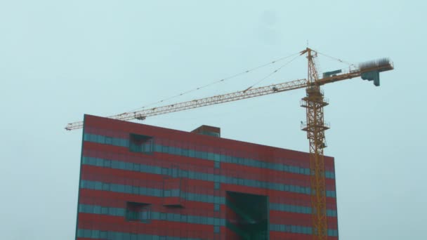 Big tower crane working on construction site. Heavy machinery on building site — Stock Video