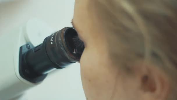 Female researcher microscoping in scientific genetic laboratory — Stock Video