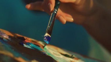Kadın sanatçı palette boya fırça ile karıştırma. Kadın el holding boya fırçası