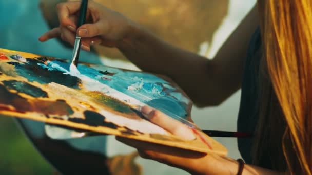 Mulher mão misturando tintas de óleo na paleta de madeira. Imagem de pintura de artista criativo — Vídeo de Stock