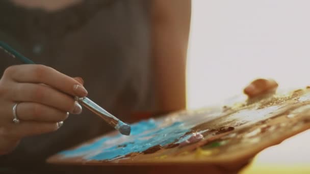 Artista femenina sosteniendo paleta sucia con pinturas. Cepillo de mano mujer — Vídeos de Stock