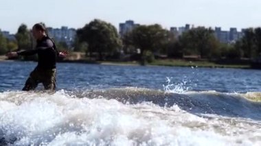 Sportif adam wakeboarding Nehri üzerinde. Dalgalar üzerinde sörf genç sporcu uyku modundan çıkarma