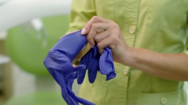 Vrouwelijke arts handen zetten van steriele handschoenen. Laboratorium werknemer handen — Stockvideo