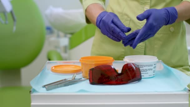 Fechar as mãos do dentista criando material de silicone para impressão dentária — Vídeo de Stock