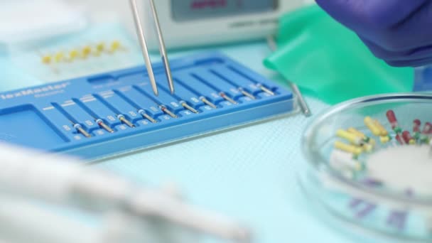 Стоматолог руки в латексных перчатках с нержавеющей стоматологического оборудования — стоковое видео