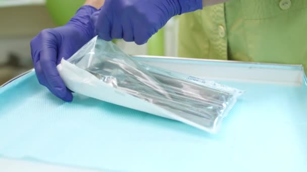 Dentist hands unpacking dentistry tools. Dental mirror and probe in steel plate — Stock Video