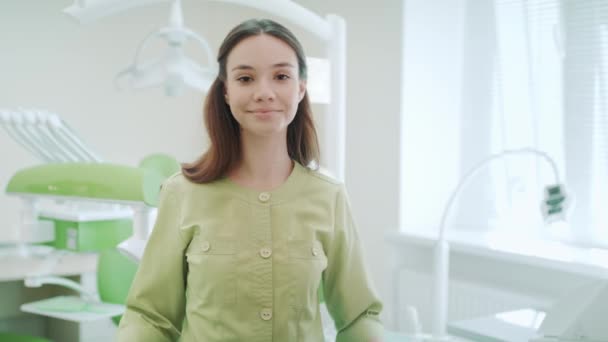 Odontólogo sonriente en el interior de la clínica dental. Retrato de mujer dentista — Vídeos de Stock