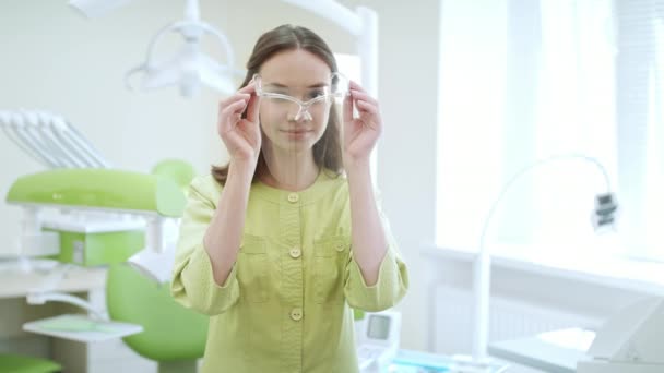 Female dentist wearing safety glasses. Happy medical student in dental clinic — Stock Video