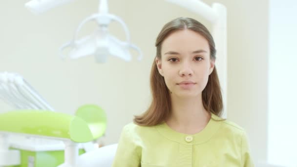 Glad tandläkare klä upp skyddande mask i tandvårdsklinik. Unga läkare — Stockvideo