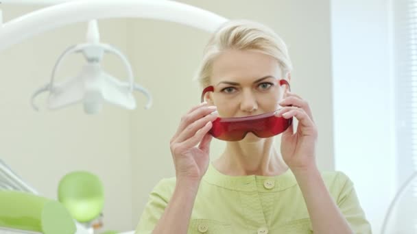 Όμορφη Γυναίκα Οδοντίατρος Ντύνοντας Υπεριώδη Πορτοκαλί Προστατευτικά Γυαλιά Γυναίκα Γιατρός — Αρχείο Βίντεο