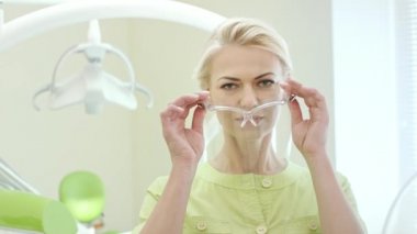 Koruyucu gözlük kadar soyunma kadın diş hekimi. Kadın doktor iş için hazırlanıyor