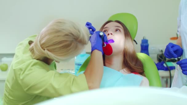 Estomatologista usando lâmpada para polimerização de materiais odontológicos — Vídeo de Stock