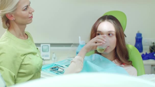 Mädchen gurgelt Mund nach Stomatologie Behandlung. Frau spült Mund — Stockvideo