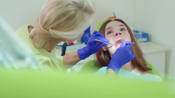 Técnico dental examinando los dientes del paciente con instrumentos dentales — Vídeos de Stock