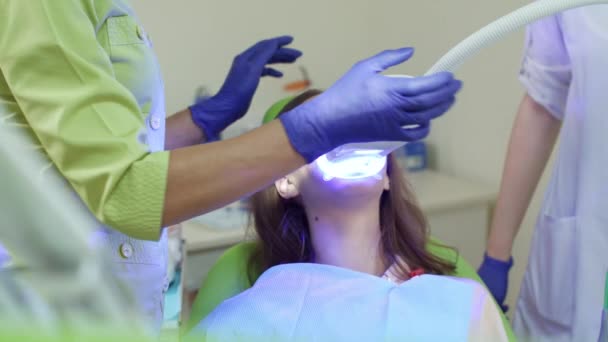Blanqueamiento dental con lámpara ultravioleta. Paciente en procedimiento de blanqueo de dientes — Vídeos de Stock