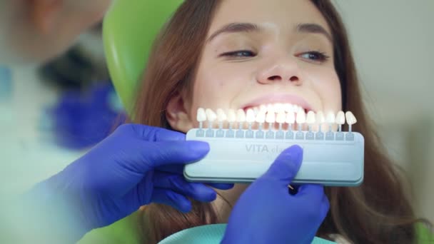 Doctor examinando la blancura de los dientes del paciente. Cerrar dentista seleccionar el color — Vídeos de Stock