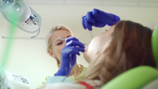 El higienista dental revisa los dientes del paciente. Trabajo profesional en Estomatología — Vídeos de Stock