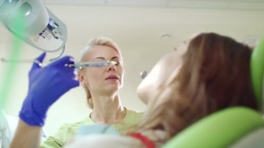 Dişçi hasta diş anestezik enjeksiyon yapıyor. Kadın stomatologist