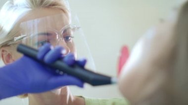 Diş hekimi diş kür ışık için ağız boşluğu kullanarak. Profesyonel Diş dolgu