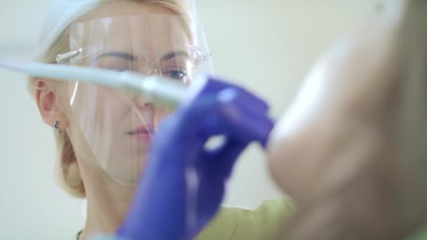 Higienista dental puliendo los dientes del paciente. Limpieza dental profesional en clínica — Vídeo de stock