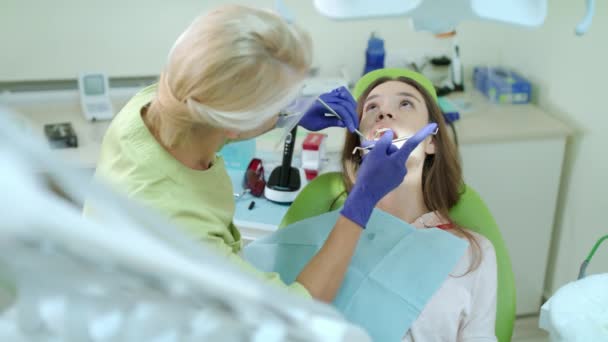 치과 의료에서 검사 환자 치아 장갑. 여성 환자를 치료 하는 치과 — 비디오