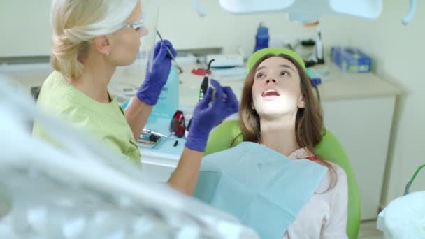 Mulher dentista tirando tampão da boca do paciente. Processo de tratamento da dor de dente — Vídeo de Stock