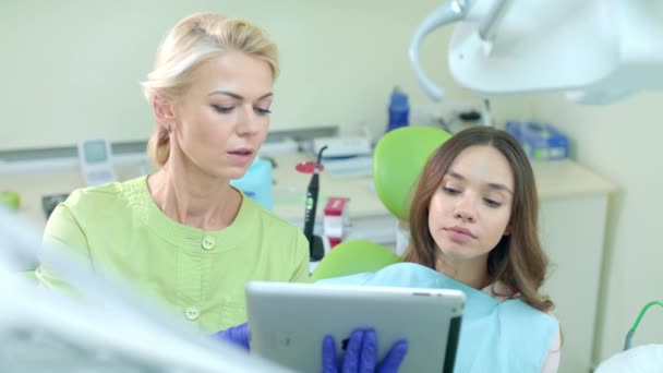 Dentista feminina usando computador tablet. Dentista mostrando plano de tratamento do paciente — Vídeo de Stock