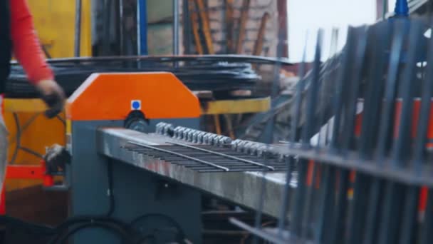 Factory worker bending grid from steel bars. Workman bends metal at factory — Stock Video