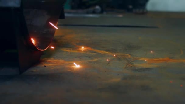 Metalen lasproces in fabriek. Close-up van lichte metalen sparks vallen op vloer — Stockvideo