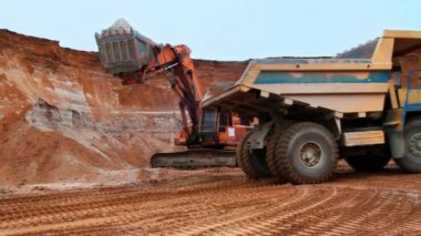 Ekskavatör kum damperli kamyona yükleniyor. Caterpillar ekskavatör kazma toprak