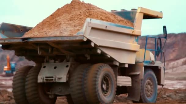 Vuile Kipper vrachtwagen transport zand op weg in steengroeve. Grote gele dumper vrachtwagen — Stockvideo