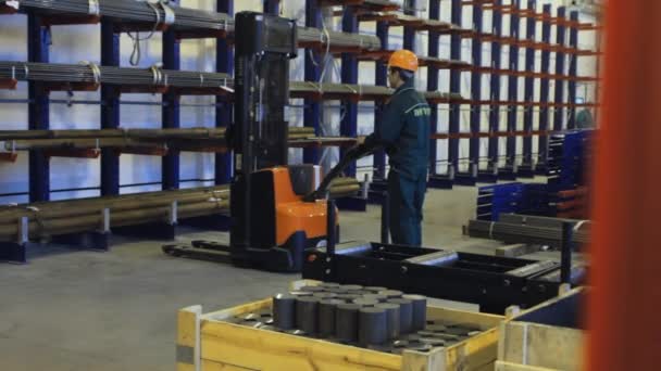 Worker loading at forklift tubes stored in warehouse. Ready pipes on shelves — Stock Video
