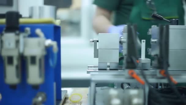 Fabrieksarbeider invoegen van metalen geprint in de machine. Man operationele draaibank — Stockvideo