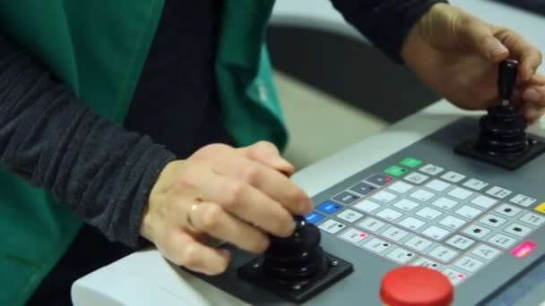 Trabajador que gestiona el proceso de producción con dos joysticks en el panel de control — Vídeo de stock