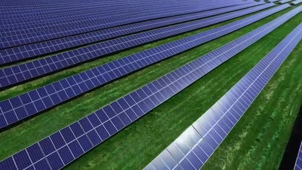 Солнечные батареи энергетической фермы при солнечном свете. Ряды фотоэлектрических панелей с воздуха — стоковое видео