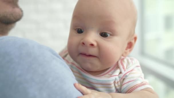 パパの手の中の小さな子供 父の手を見下ろしてのかわいい赤ちゃん 周りを見てかわいい幼児 — ストック動画