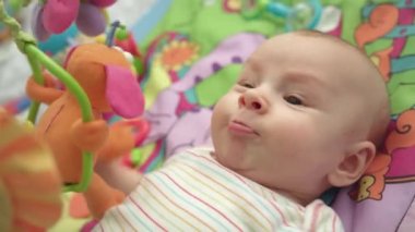 Küçük çocuğun yüzünü kapat. Mutlu bebek oyuncakları ile renkli mat portresi
